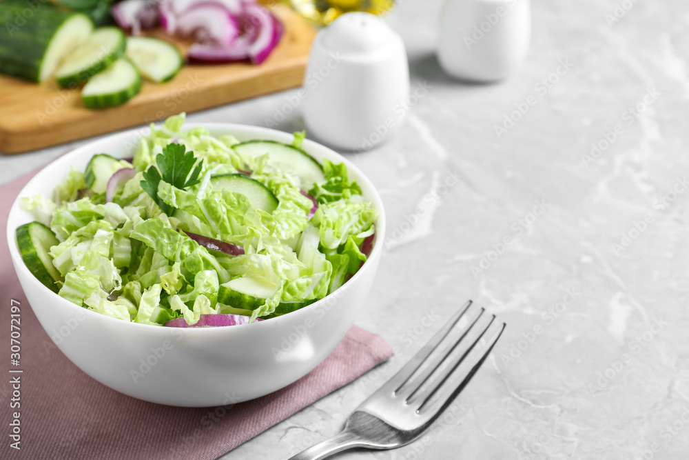 Tasty salad with cabbage and cucumbers on light grey marble table Tasty salad with cabbage and cucumbers on light grey marble table