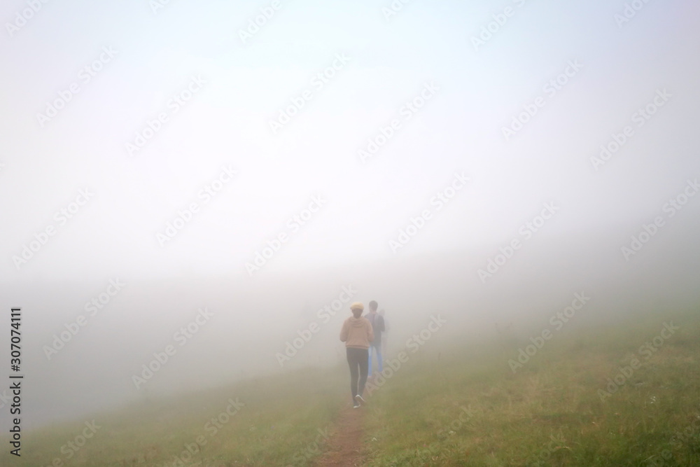White fog cover the People or traveler walk on the Mountain hill with grass field or white clouds