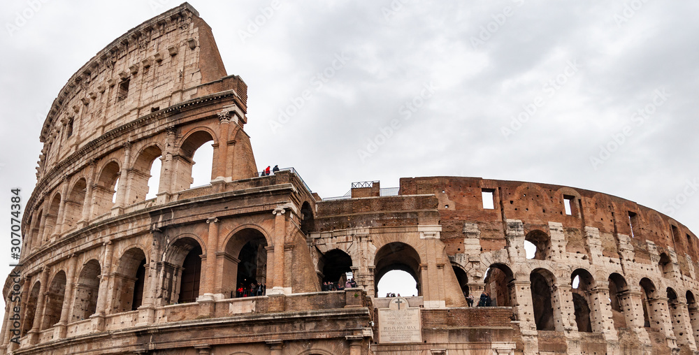 Rome Italy. Exterior of the Colosseum, famous for shows with gladiators in the Roman Empire, inserted in the new seven wonders of the world. Detail of the typical architectural arches and friezes.