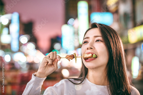 Asian young woman enjoy  street food in  Night Market
