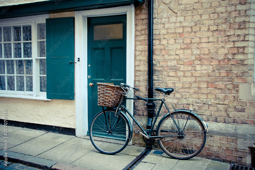 Bicycle with a basket is leaning against the front door