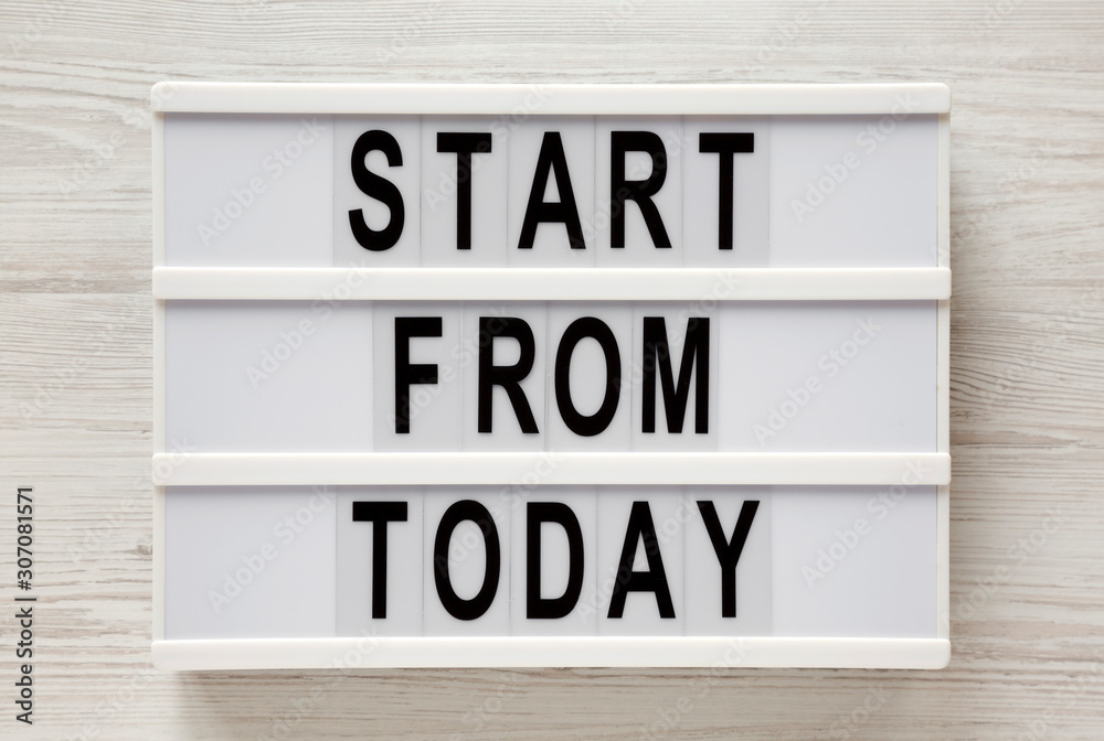 'Start from today' words on a lightbox on a white wooden background, top view. Overhead, from above, flat lay. Closeup. 'Start from today' words on a lightbox on a white wooden background, top view. Overhead, from above, flat lay. Closeup.