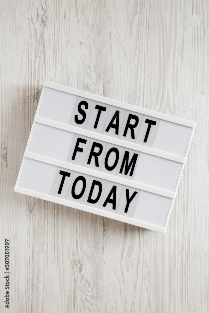 'Start from today' words on a modern board on a white wooden background, top view. Overhead, from above, flat lay. Close-up. 'Start from today' words on a modern board on a white wooden background, top view. Overhead, from above, flat lay. Close-up.