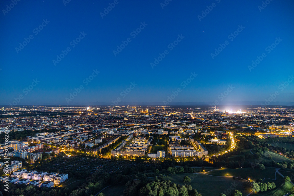 Fototapeta premium Abendlicher Panoramablick über München mti dem hell erleuchteten Oktoberfest