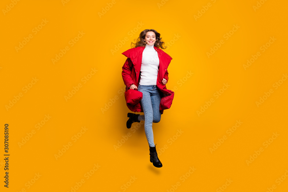 Full body photo of amazing lady jumping high walking street sale shopping wear jeans shoes white pullover red long winter coat isolated yellow color background