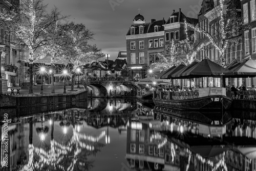 View on the New Rhine and Visbrug with terrace boats and trees with christmas ornaments during blue hour, Leiden, the Netherlands