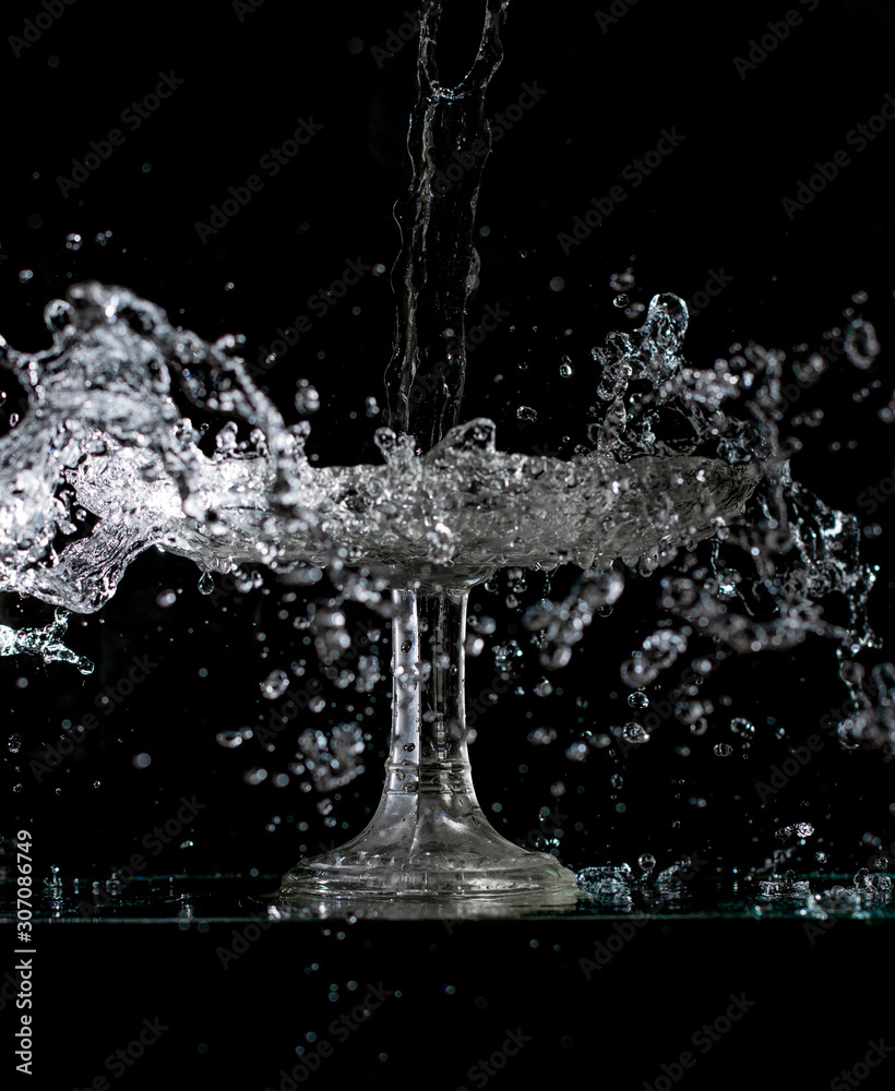 splash and spatter of water in a crystal vase on a black background
