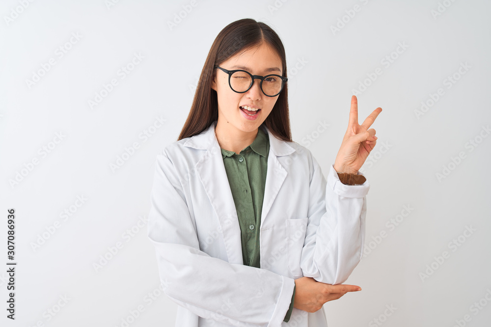 Young chinese scientist woman wearing coat and glasses over isolated white background smiling with happy face winking at the camera doing victory sign. Number two. Young chinese scientist woman wearing coat and glasses over isolated white background smiling with happy face winking at the camera doing victory sign. Number two.