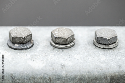 Three gray bolts in a row, close-up