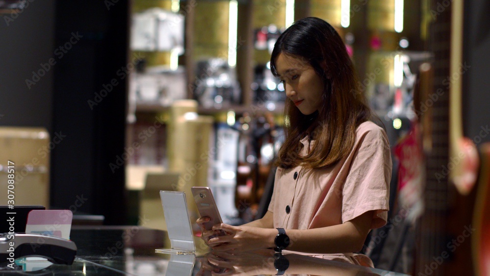 Young woman paying by scanning QR Code with smartphone