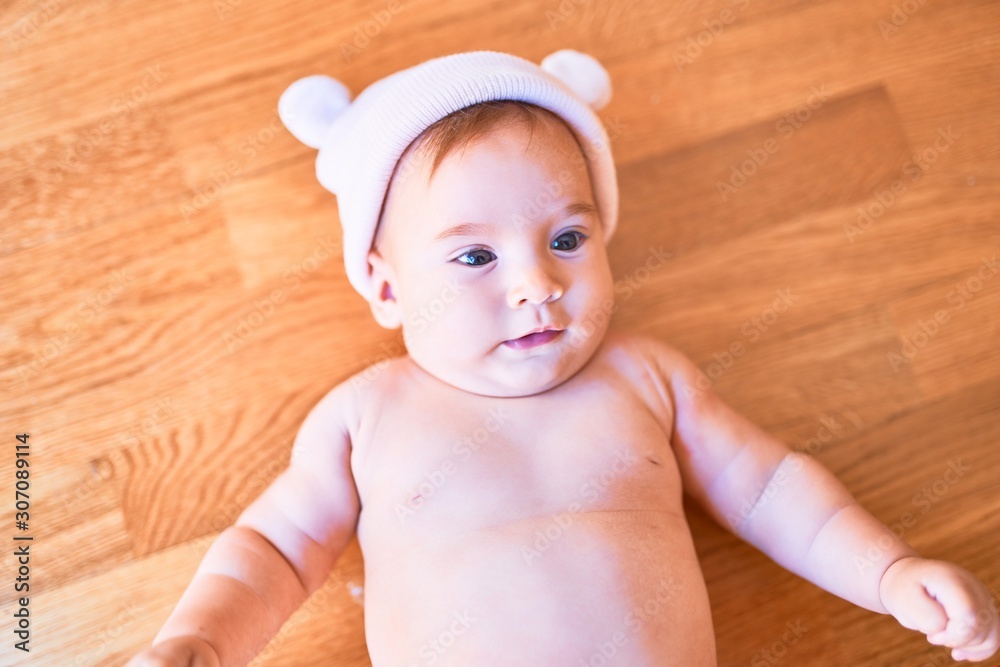 Adorable baby lying down on the sofa at home. Newborn wearing fanny hat relaxing and resting comfortable Adorable baby lying down on the sofa at home. Newborn wearing fanny hat relaxing and resting comfortable