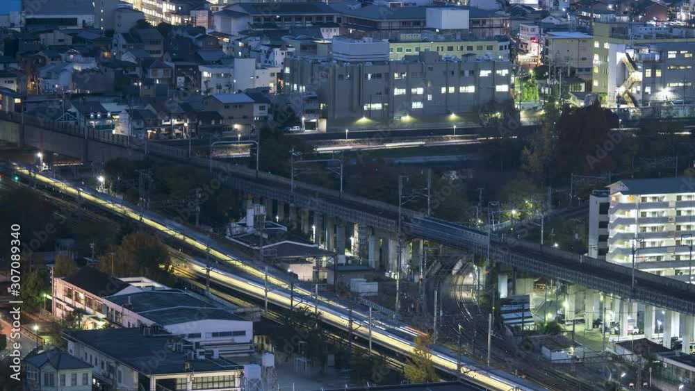 KYOTO, JAPAN, Bullet trains and commuter trains converging at twilight, heading towards Train station. Tourism and Transportation Timelapse.