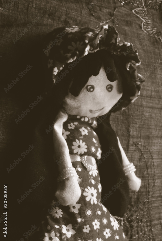 Old doll with floral red gown and hat