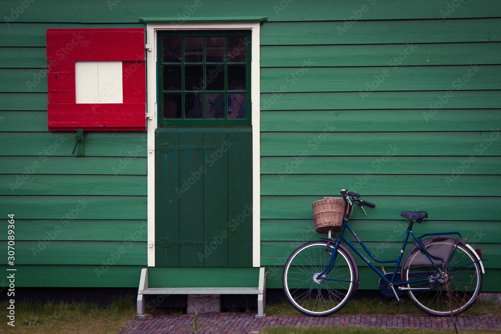 Bicycle standing near the green house Bicycle standing near the green house