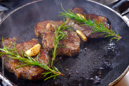 Grilled premium rib eye beef steak in the pan, cooking steak in the kitchen on a dark background, top view