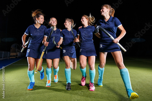 Five field hockey players celebrate the victory