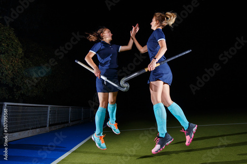 Two field hockey players celebrate the victory