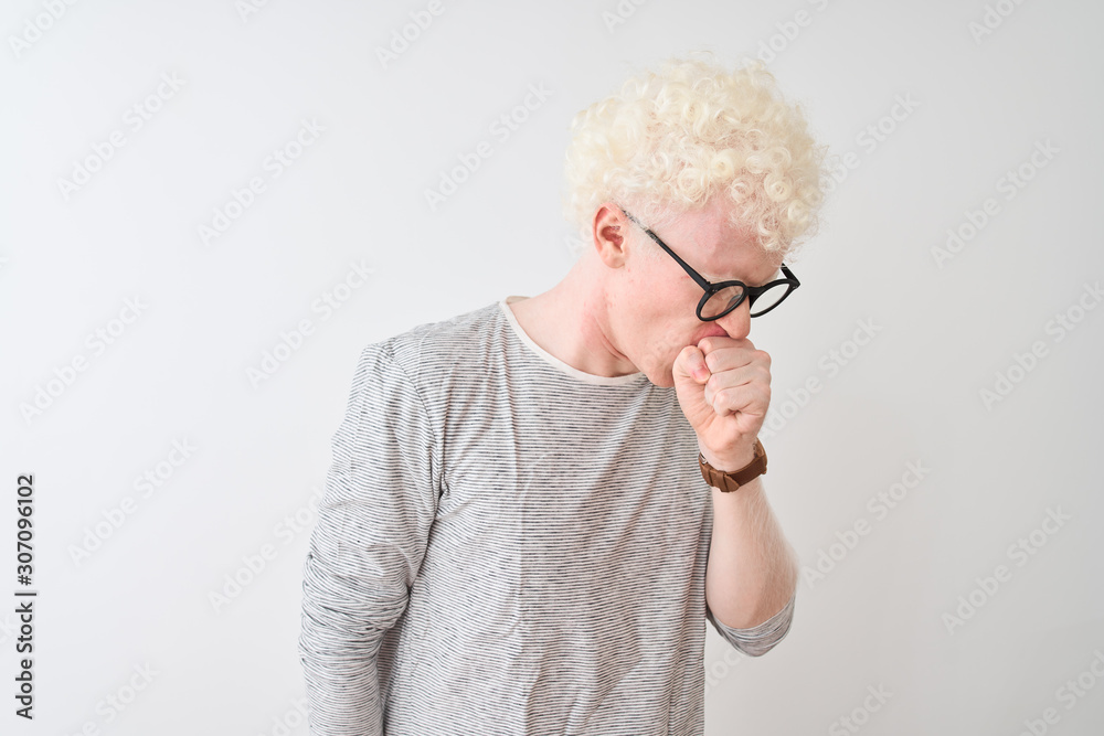 Young albino blond man wearing striped t-shirt and glasses over isolated white background feeling unwell and coughing as symptom for cold or bronchitis. Healthcare concept. Young albino blond man wearing striped t-shirt and glasses over isolated white background feeling unwell and coughing as symptom for cold or bronchitis. Healthcare concept.