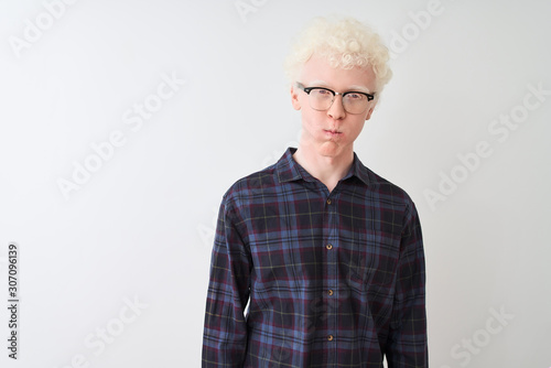 Young albino blond man wearing casual shirt and glasses over isolated white background puffing cheeks with funny face. Mouth inflated with air, crazy expression.