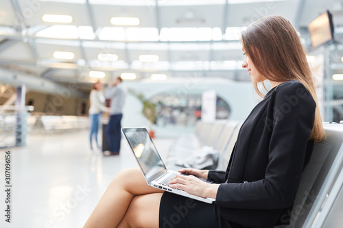 Young businesswoman with laptop computer in the airport photo