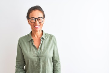 Middle age woman wearing green shirt and glasses standing over isolated white background with a happy and cool smile on face. Lucky person.