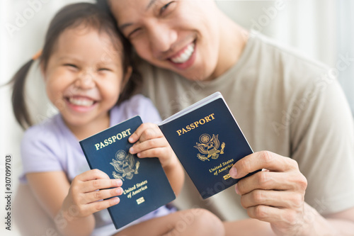 Happy immigrant family becoming new American citizens, holding US passports. photo