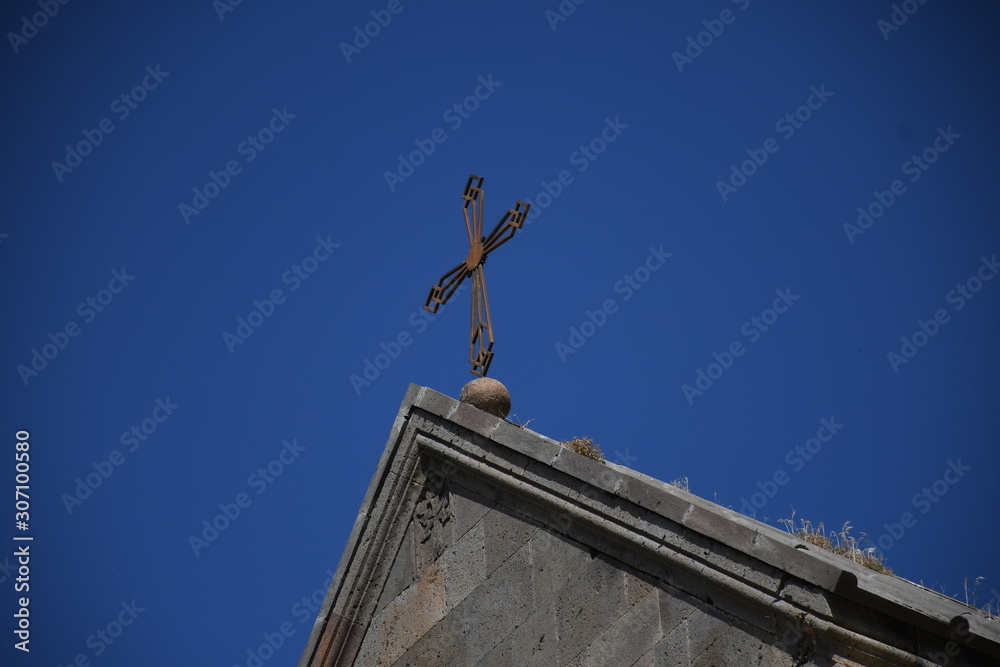 Cross over the Armenian church on the sky background