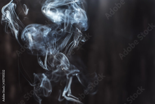 Image of backlit puffs of smoke, on a dark background.