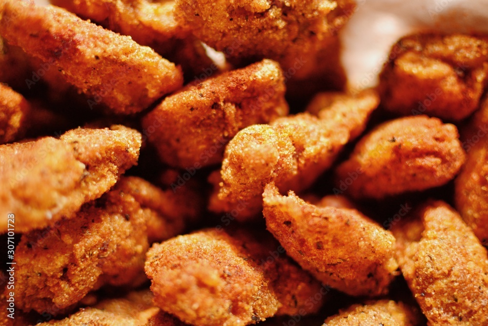 Chicken nuggets with a crispy crust. Delicious chicken meat on a wooden background. Fried meat, breast. 