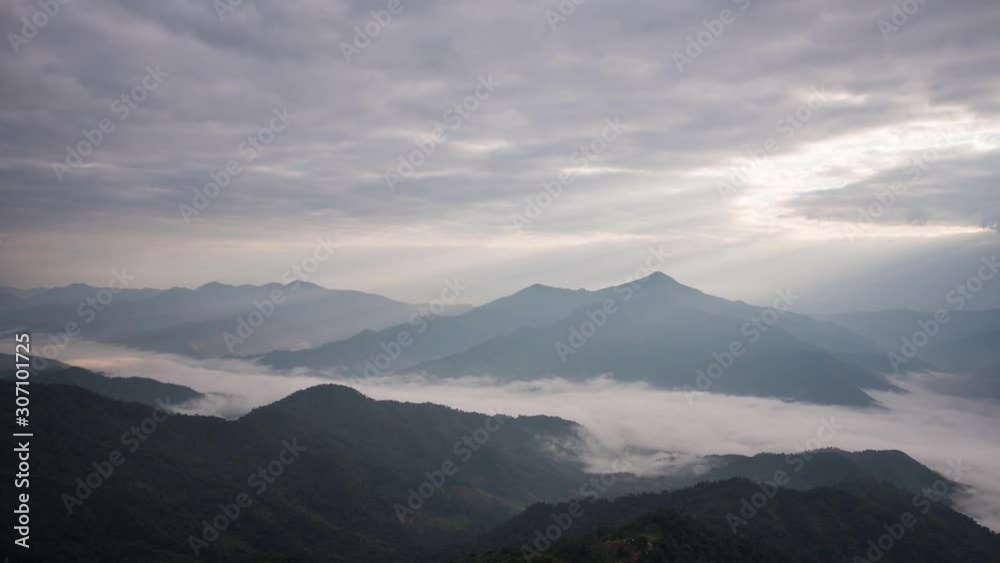 Timelapse. Sun rising over mountains with fog and the light shines beautifully. A tourist destination on a hilltop during the foggy and beautiful light in the morning and sunset in Chiang Rai Thailand Timelapse. Sun rising over mountains with fog and the light shines beautifully. A tourist destination on a hilltop during the foggy and beautiful light in the morning and sunset in Chiang Rai Thailand