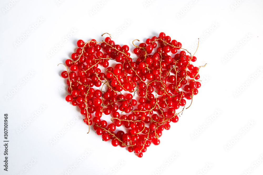 Love concept of red fresh fresh redcurrant berries in the shape of a heart on a white background. Valentines Day