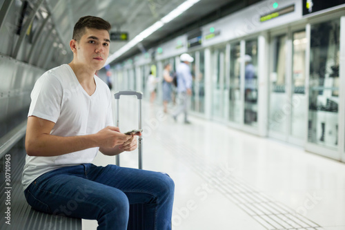 Man using phone in underground carriage