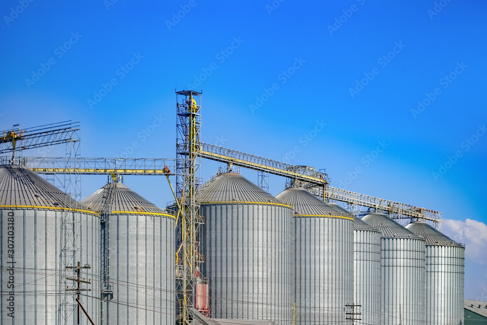 Agricultural Silos ,Industrial silos Storage and drying of grains with Blue Sky and White Clouds Agricultural Silos ,Industrial silos Storage and drying of grains with Blue Sky and White Clouds