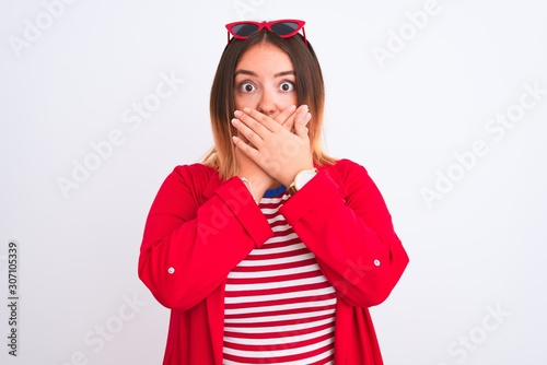 Young beautiful woman wearing striped t-shirt and jacket over isolated white background shocked covering mouth with hands for mistake. Secret concept.