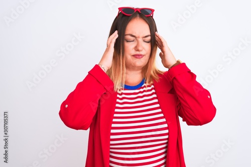 Young beautiful woman wearing striped t-shirt and jacket over isolated white background with hand on head for pain in head because stress. Suffering migraine.
