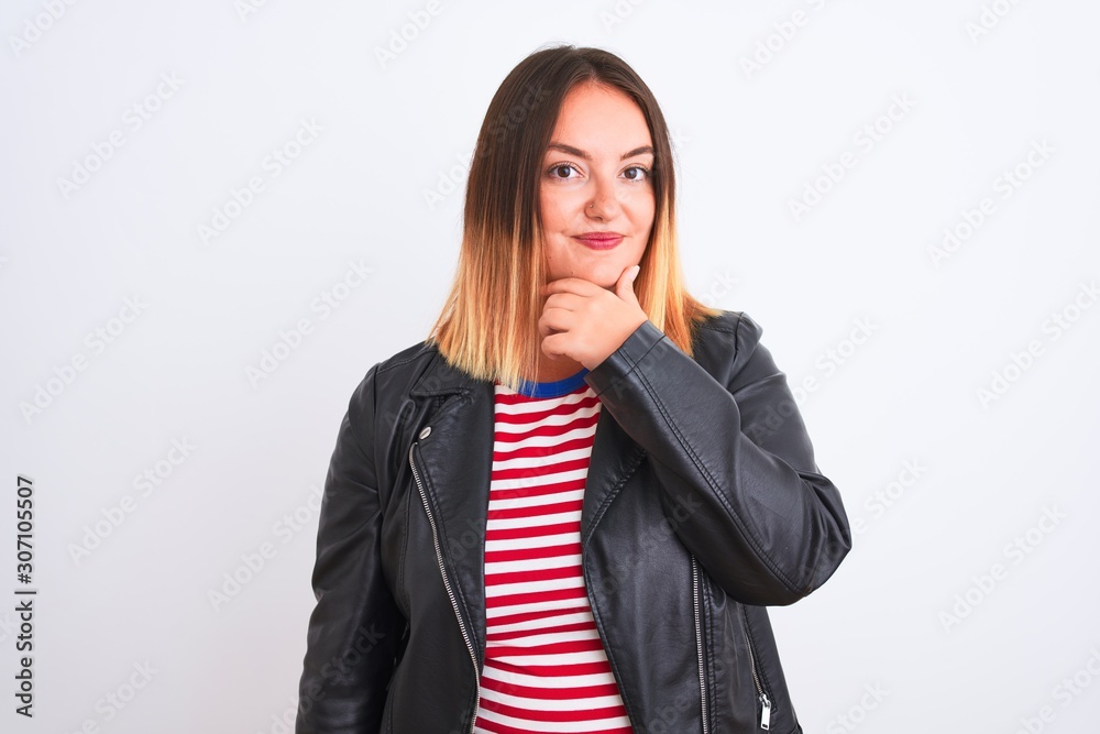 Young beautiful woman wearing striped shirt and jacket over isolated white background looking confident at the camera with smile with crossed arms and hand raised on chin. Thinking positive. Young beautiful woman wearing striped shirt and jacket over isolated white background looking confident at the camera with smile with crossed arms and hand raised on chin. Thinking positive.