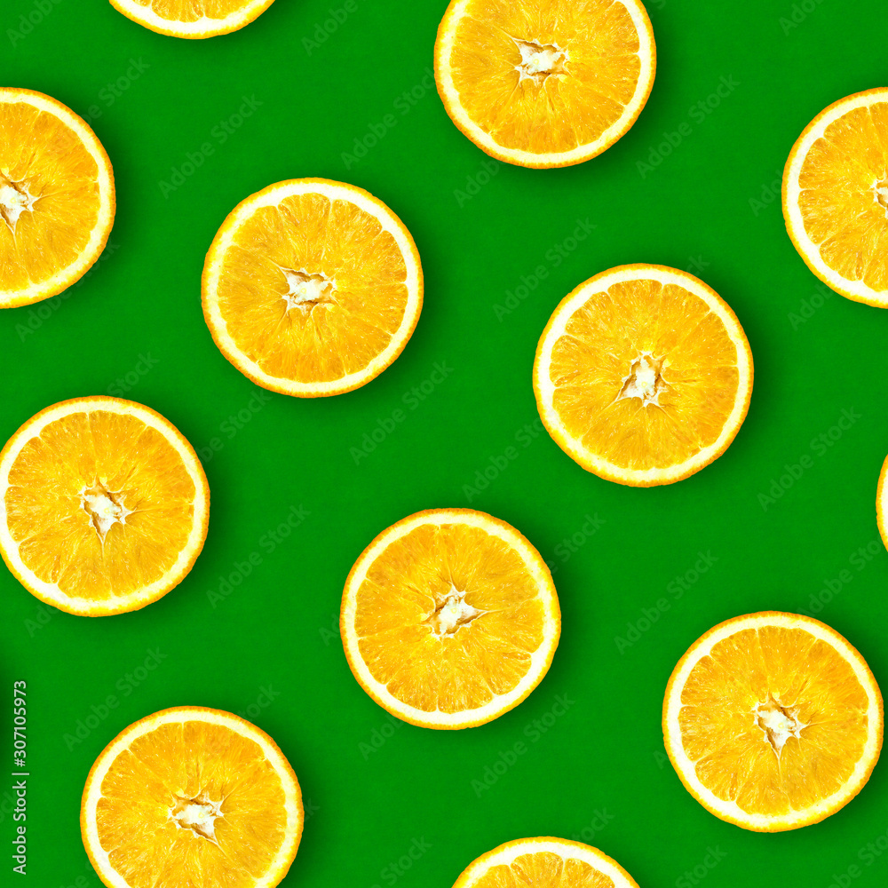 Obraz premium Seamless pattern of oranges. Bright green background. Juicy orange in a cut. Citrus fruit.