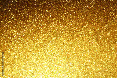 gold Sparkling Lights Festive background with texture. Abstract Christmas twinkled bright bokeh defocused and Falling stars. Winter Card or invitation	