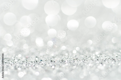 Silver Sparkling Lights Festive background with texture. Abstract Christmas twinkled bright bokeh defocused and Falling stars. Winter Card or invitation 