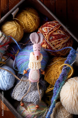 Textile handmade toy of pink lady mouse sitting in a box with balls of thread