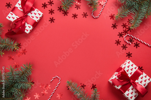 Christmas frame with gifts  balls  fir tree on red background. Greeting card. Happy New Year. Space for text