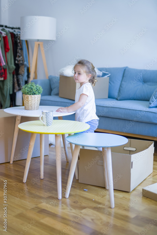 Beautiful toddler child girl playing with boxes at new home Beautiful toddler child girl playing with boxes at new home
