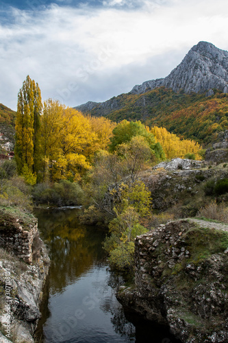 Autumnal landscape on the Curue  o river. Cueto Ancino in the background  Le  n  Spain