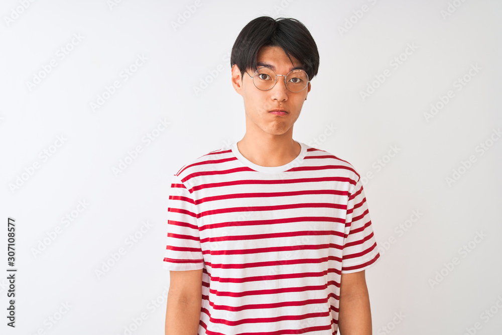 Young chinese man wearing glasses and striped t-shirt standing over isolated white background depressed and worry for distress, crying angry and afraid. Sad expression. Young chinese man wearing glasses and striped t-shirt standing over isolated white background depressed and worry for distress, crying angry and afraid. Sad expression.