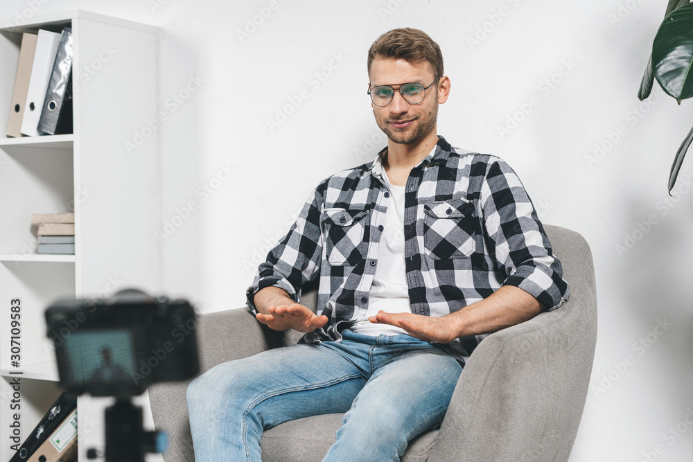 Young adult man using video camera, creative online content