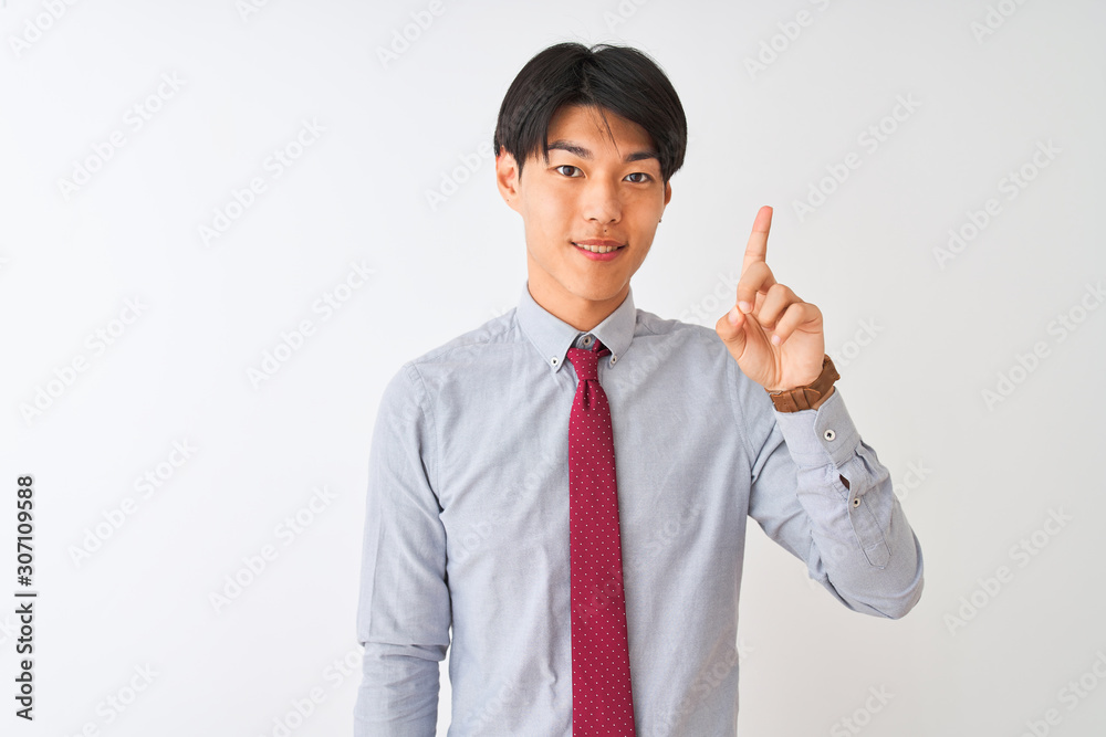 Chinese businessman wearing elegant tie standing over isolated white background showing and pointing up with finger number one while smiling confident and happy. Chinese businessman wearing elegant tie standing over isolated white background showing and pointing up with finger number one while smiling confident and happy.