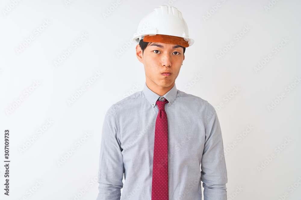 Chinese architect man wearing tie and helmet standing over isolated white background skeptic and nervous, frowning upset because of problem. Negative person. Chinese architect man wearing tie and helmet standing over isolated white background skeptic and nervous, frowning upset because of problem. Negative person.