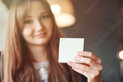 Business Woman hand holding square blank clean sticker mock up. Close up background place for text