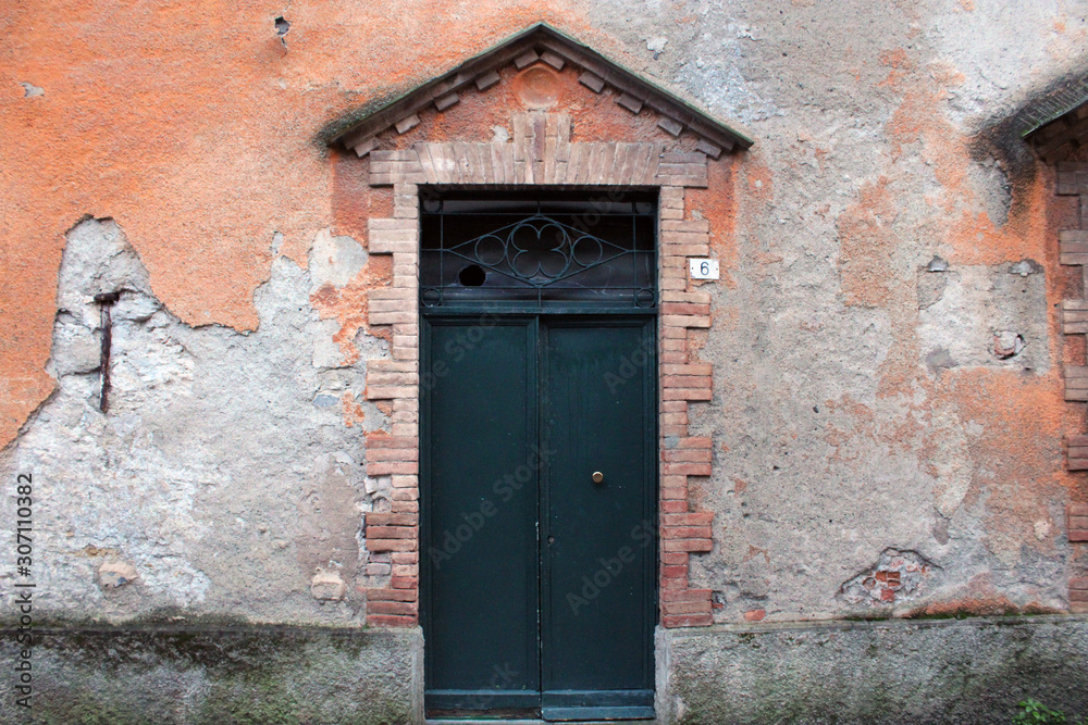 Porta con frontone e mura ammalorate Porta con frontone e mura ammalorate