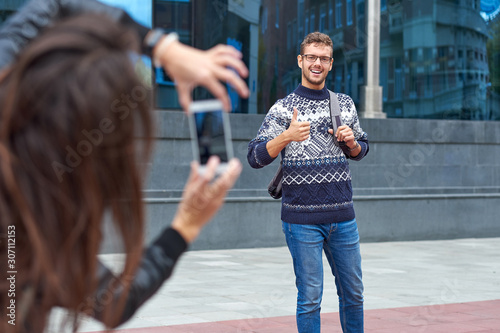 Couple of tourists making photo. Man posing for vacation photo in urban city tour.